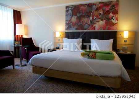 Mainz, Germany, July 8, 2017: Hotel Room with Double Bed and Red Lounge Chair 125958043