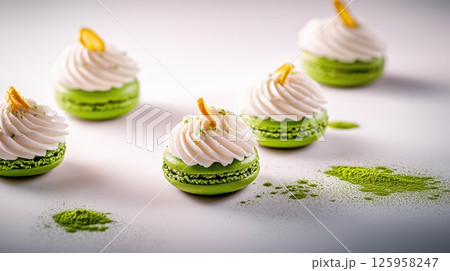 Delicious green macaroons with creamy frosting and almond topping arranged artistically on a white surface showcasing a vibrant dessert concept Delicious green macaroons with creamy frosting and almond topping arranged artistically on a white surface showcasing a vibrant dessert concept 125958247
