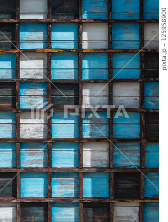 Wooden grid with colorful weathered blue and white panels, background, texture 125958900
