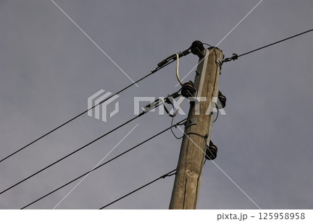 A tall wooden pole with wires on top of it 125958958