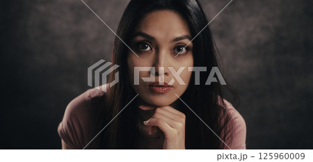Thoughtful Woman Posing in Studio Setting 125960009
