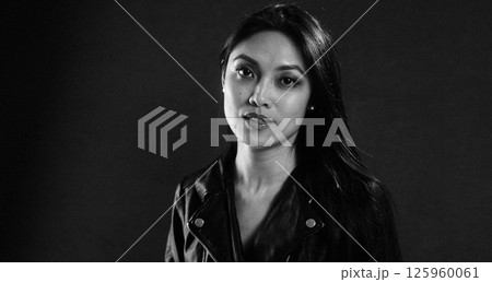 Thoughtful Woman in Black Leather Jacket Posing Thoughtful Woman in Black Leather Jacket Posing 125960061