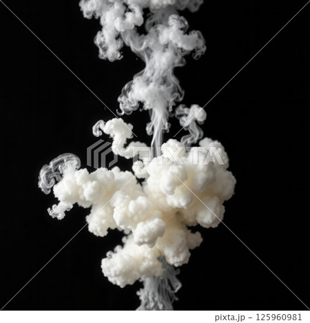 Dramatic fluffy white smoke explosion burst with trailing wisps on dark black background Dramatic fluffy white smoke explosion burst with trailing wisps on dark black background 125960981