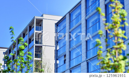 Eco apartment building saving energy and fresh air. Modern block of flats in green area, residential apartment and luxury house complex.  125961931