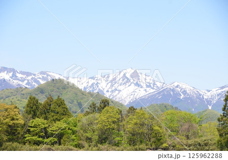 残雪の谷川岳と田園風景 125962288