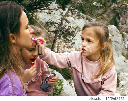 mother with daughter outside doing makeup having fun mother with daughter outside doing makeup having fun 125962481