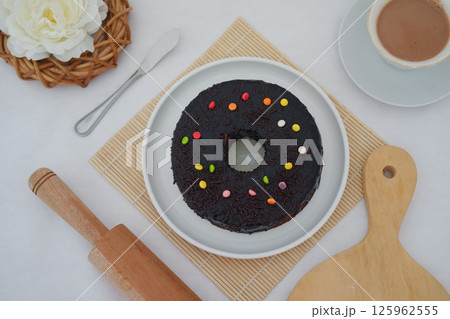 a large chocolate-glazed topped with chocolate sprinkles 125962555
