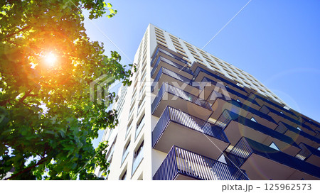 Eco apartment building saving energy and fresh air. Modern block of flats in green area, residential apartment and luxury house complex.  125962573