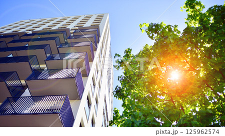 Eco apartment building saving energy and fresh air. Modern block of flats in green area, residential apartment and luxury house complex.  125962574