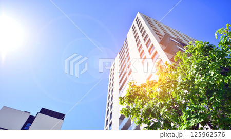 Eco apartment building saving energy and fresh air. Modern block of flats in green area, residential apartment and luxury house complex.  125962576