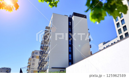 Eco apartment building saving energy and fresh air. Modern block of flats in green area, residential apartment and luxury house complex.  125962589