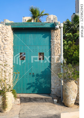 Blue wooden doors gates with metal round handles 125962943