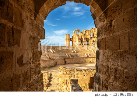 View from the arch to ancient african Roman Colosseum amphitheatre arena, ruins and columns, El Jem, Mahdia View from the arch to ancient african Roman Colosseum amphitheatre arena, ruins and columns, El Jem, Mahdia 125963888