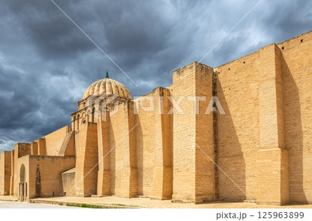 Walls and dome of the Great Mosque of Uqba with grey clouds in the sky, Kairouan, Tunis Walls and dome of the Great Mosque of Uqba with grey clouds in the sky, Kairouan, Tunis 125963899