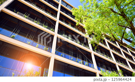 Modern city eco office building with tree. Detail shot of modern architecture facade,business concepts. Environment. Modern building and trees, double exposure. 125964424