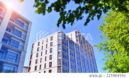 Eco apartment building saving energy and fresh air. Modern block of flats in green area, residential apartment and luxury house complex.  125964591
