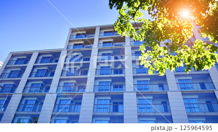 Eco apartment building saving energy and fresh air. Modern block of flats in green area, residential apartment and luxury house complex.  125964595