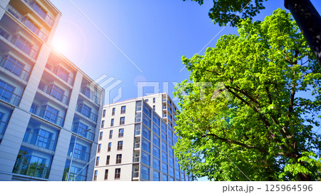 Eco apartment building saving energy and fresh air. Modern block of flats in green area, residential apartment and luxury house complex.  125964596