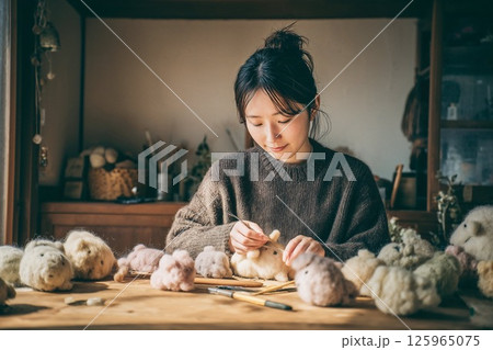 羊毛フェルトでぬいぐるみを制作する女性 125965075
