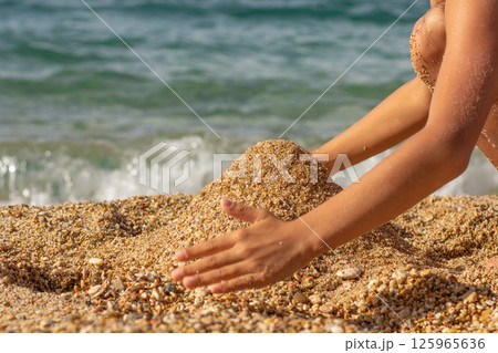 Caucasian child hands building sand castle Caucasian child hands building sand castle 125965636