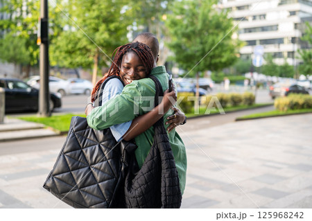 Happy black wife greets husband with smile, family reunion outdoors. Siblings meet each other 125968242