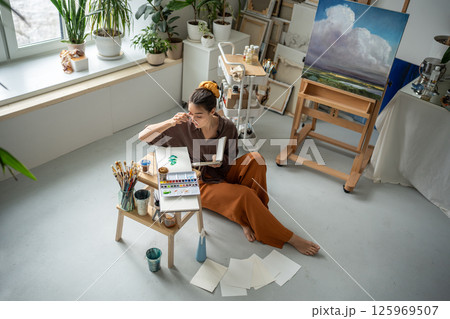 Top view pensive girl contemplate painting idea, working with watercolors and palette in art studio 125969507