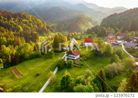 Calm idyllic village in Slovenian mountains at sunrise, summer travel concept Calm idyllic village in Slovenian mountains at sunrise, summer travel concept 125970172