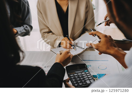 Team of financial advisory services. Asian advisor showing plan of investment to clients in the consultancy office. 125971280