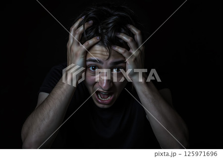 A man with a shocked expression holding his head. A man with a shocked expression holding his head. 125971696