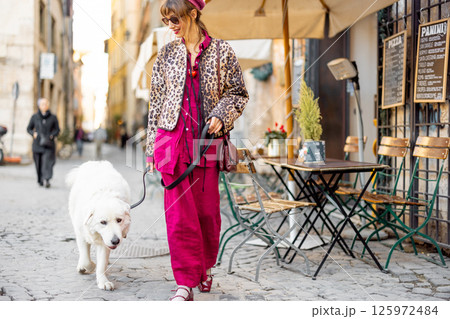 Woman walking dog on Roman street Woman walking dog on Roman street 125972484