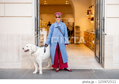 Woman and her dog outside a boutique Woman and her dog outside a boutique 125972511