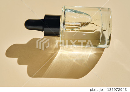 Oily serum with peptides on a beige background. Oily serum with peptides on a beige background. 125972948