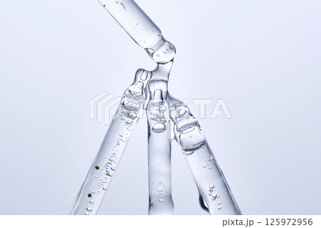 Four different face serum pipettes on a neutral background. Four different face serum pipettes on a neutral background. 125972956