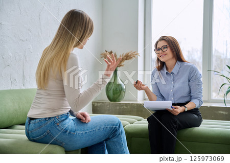 Professional female therapist counselor psychologist working with young woman patient Professional female therapist counselor psychologist working with young woman patient 125973069