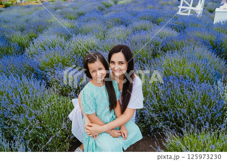 Mother and daughter are smiling. A genuine smile from the girl with her mom.  125973230