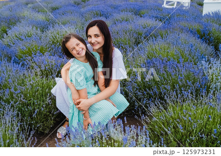 A beautiful European girl with a young woman in a field of purple flowers. A beautiful European girl with a young woman in a field of purple flowers. 125973231