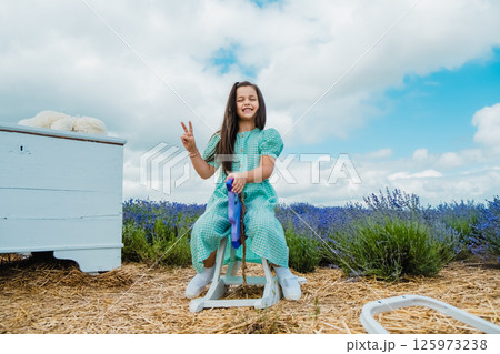A cute girl on a wooden toy rocking horse in a lavender field. A cute girl on a wooden toy rocking horse in a lavender field. 125973238