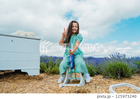 Wooden rocking horse toy in a lavender field. Beautiful girl riding a toy rocking horse. Wooden rocking horse toy in a lavender field. Beautiful girl riding a toy rocking horse. 125973240