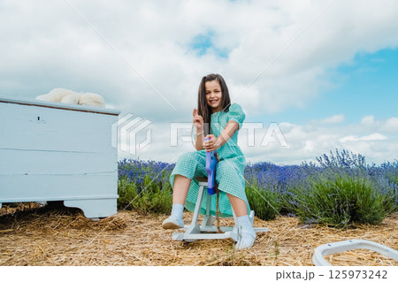 Girl swinging on a purple toy horse. Girl swinging on a purple toy horse. 125973242