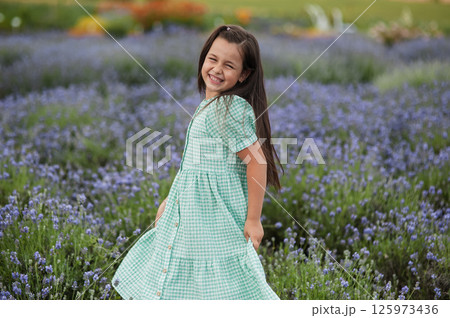 A little girl in a beautiful dress in a field. 125973436