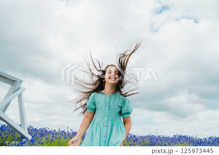 A little girl jumps high in a field of lavender. Fragrant lavender field. 125973445