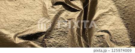 Golden foil surface with a polished, crumpled texture. Elegant, shiny drapery creating a beautiful 125974009