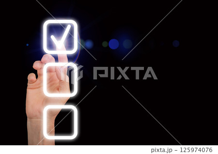 A glowing checkmark on a digital checklist, symbolizing completion and success. The finger taps the A glowing checkmark on a digital checklist, symbolizing completion and success. The finger taps the 125974076