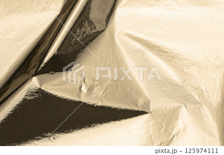 Gold foil texture with a crinkled surface, casting soft shadows. VIP-level shine and light Gold foil texture with a crinkled surface, casting soft shadows. VIP-level shine and light 125974111