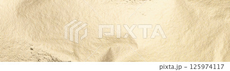 Gold foil texture with a soft, pale background. Smooth, shiny surface with subtle shimmer and Gold foil texture with a soft, pale background. Smooth, shiny surface with subtle shimmer and 125974117