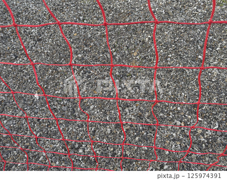 Red Mesh Fence Against a Gravel Surface in a Construction Area 125974391
