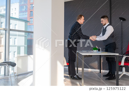 Two Caucasian men shaking hands. Interview or business meeting. Two Caucasian men shaking hands. Interview or business meeting. 125975122