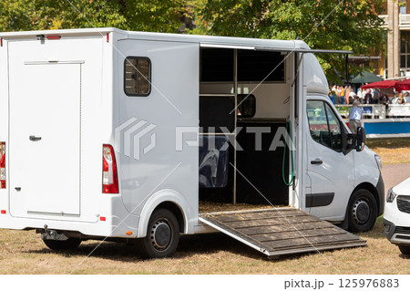 Horse box cargo trailer transport with open tailgate with hay and manure and horse transportation van at farm or ranch. Horsebox carriage lorry animal livestock tranport haulage 125976883