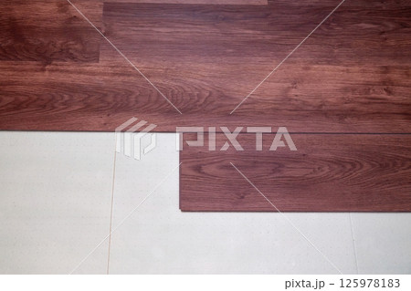 Top view of the laying of laminate boards on the underlying floor layer. Home renovation concept Top view of the laying of laminate boards on the underlying floor layer. Home renovation concept 125978183