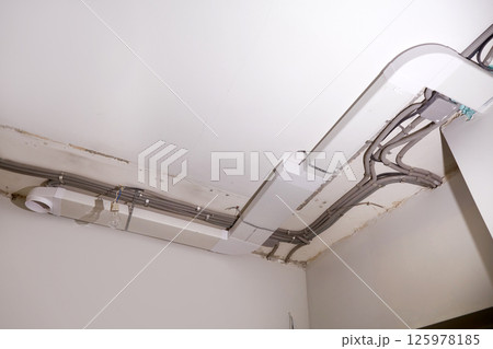 Installation of electrical wiring and ventilation on the ceiling. Installation of electrical wiring and ventilation on the ceiling. 125978185